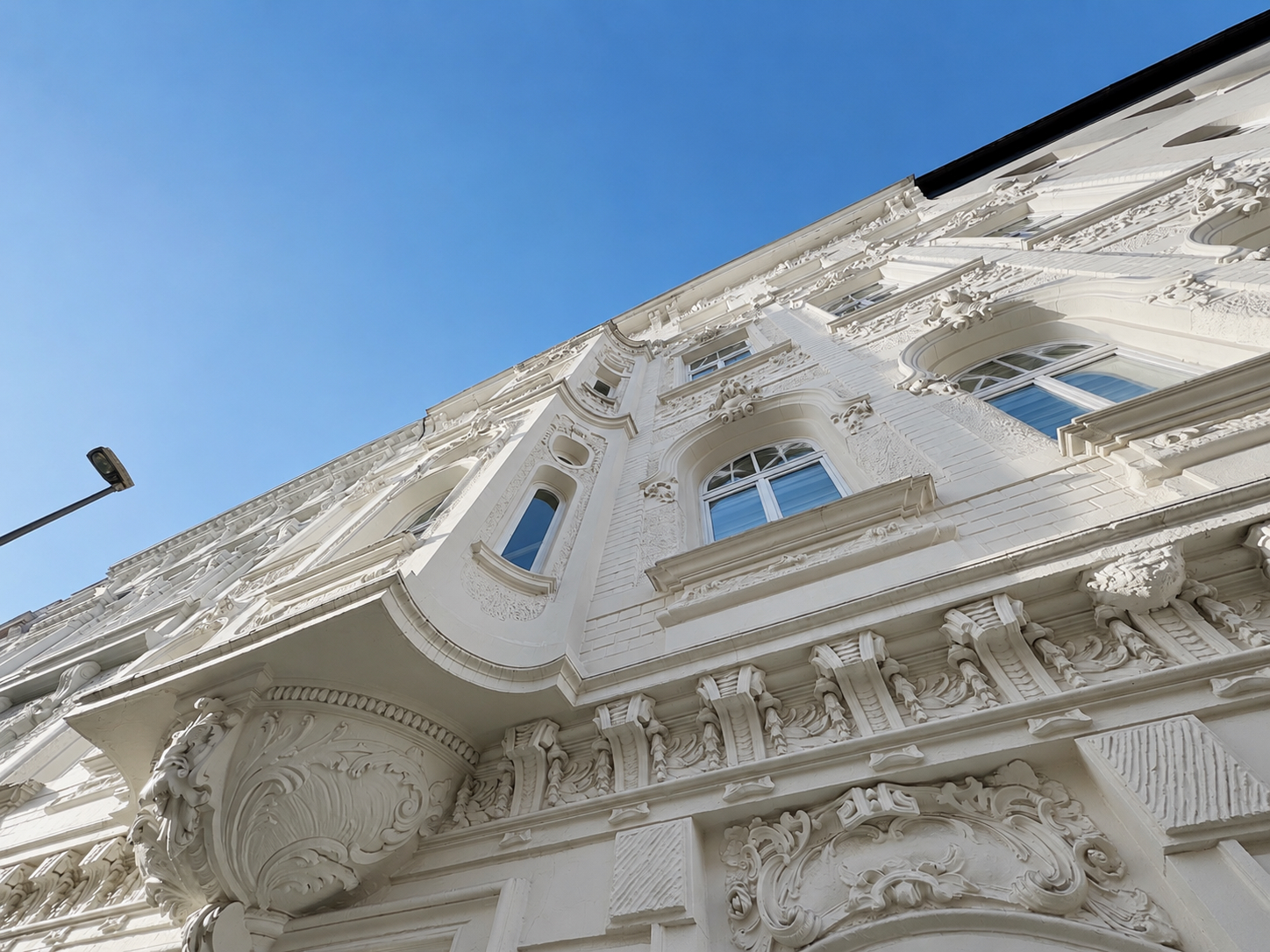 Stuckfassade in Untersicht gegen blauen Himmel